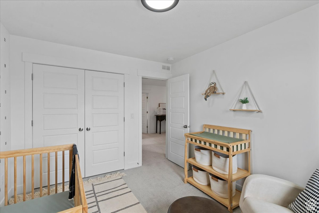 Carpeted bedroom featuring a closet