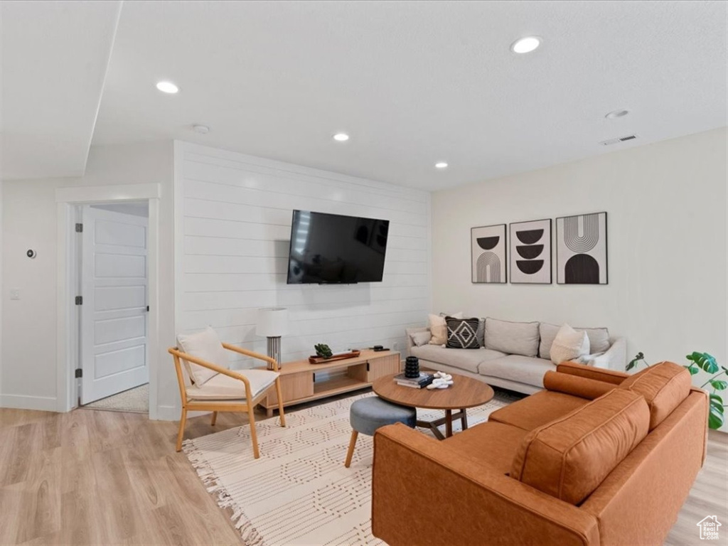 Living room with light wood-type flooring, recessed lighting, and baseboards