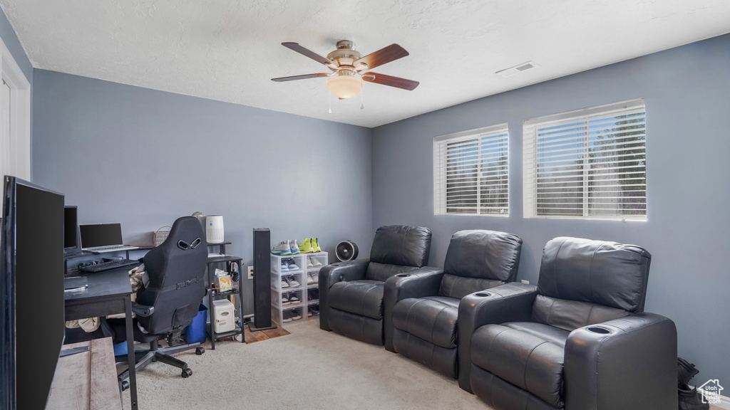 Carpeted office with a ceiling fan