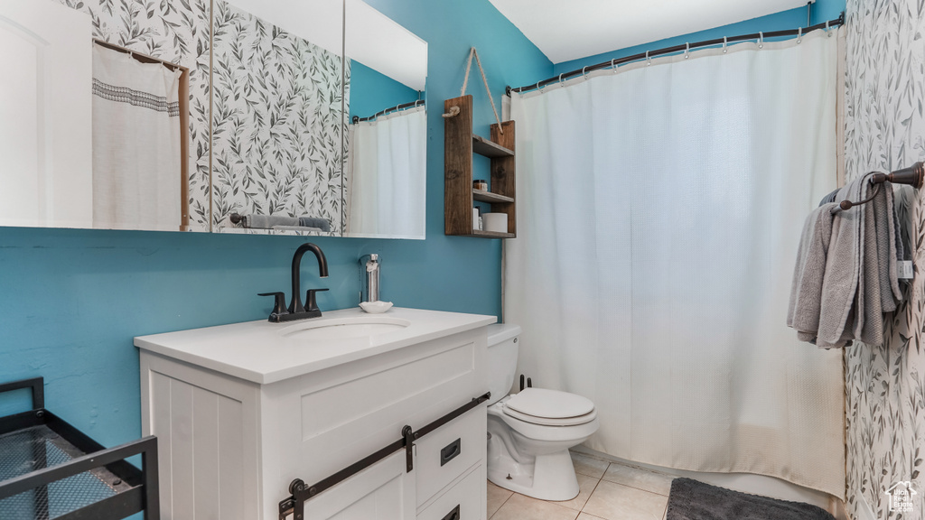 Bathroom with tile patterned floors, toilet, and vanity