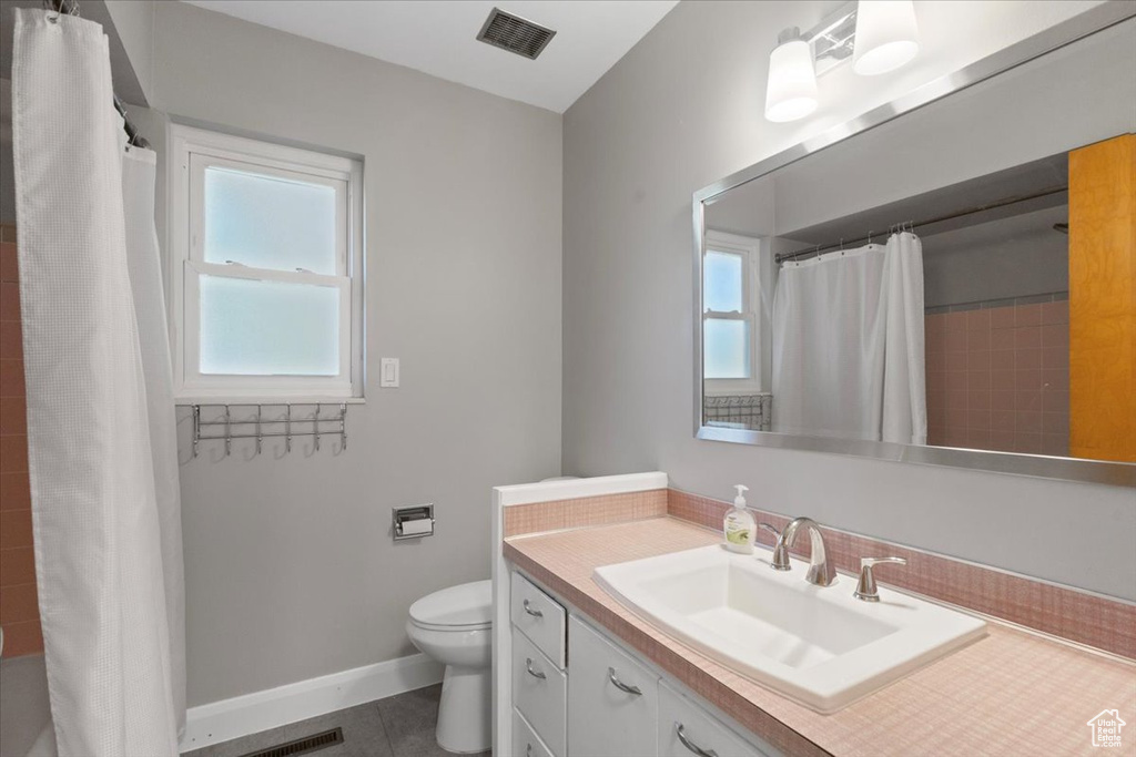 Bathroom with toilet, tile patterned floors, vanity, a shower with curtain, and baseboards
