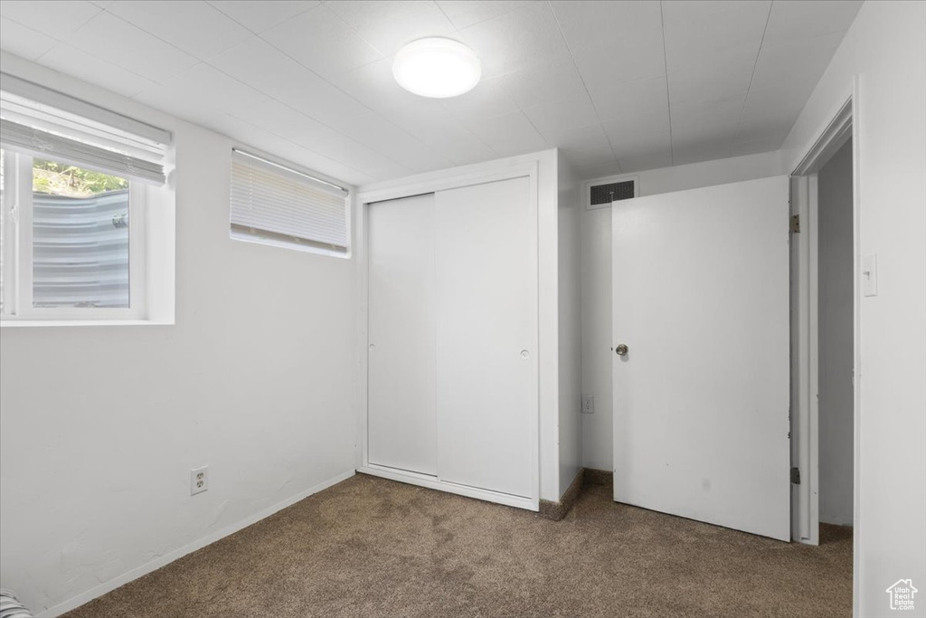 Unfurnished bedroom featuring carpet and a closet