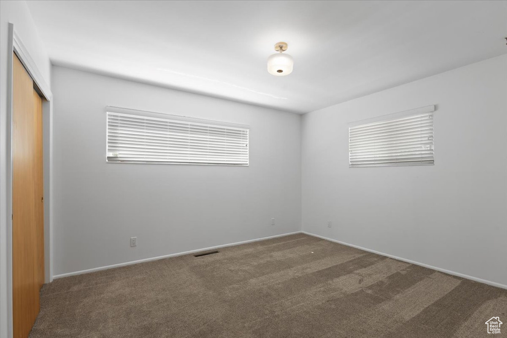 Unfurnished bedroom with carpet floors, a closet, and baseboards