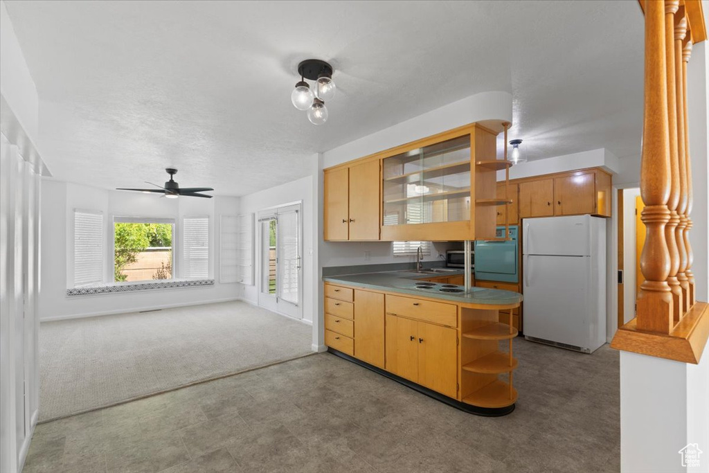 Kitchen featuring freestanding refrigerator, open shelves, ceiling fan, a sink, and tile patterned floors