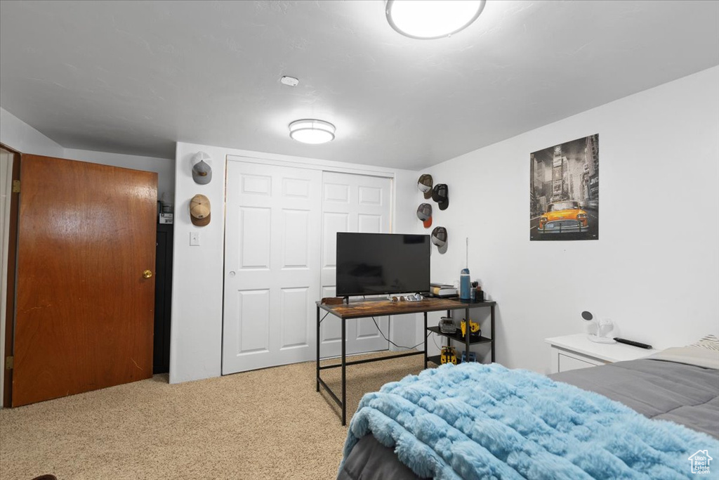Bedroom with carpet floors, a desk, and a closet