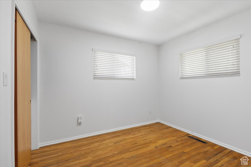 Unfurnished bedroom featuring a closet, light wood-type flooring, and baseboards