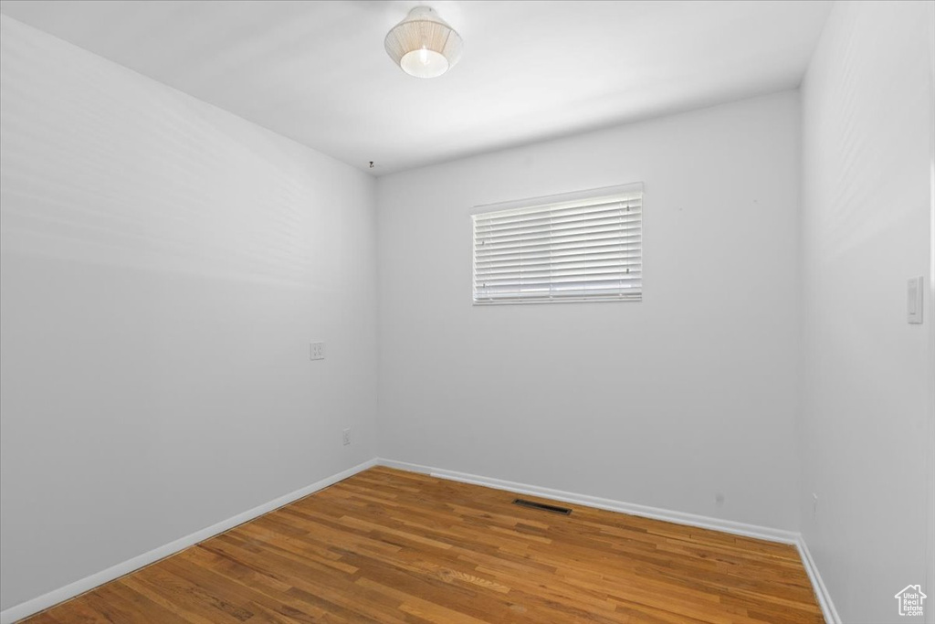 Spare room featuring baseboards and wood finished floors