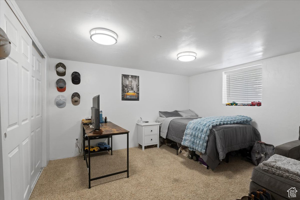 Bedroom with light carpet and a closet