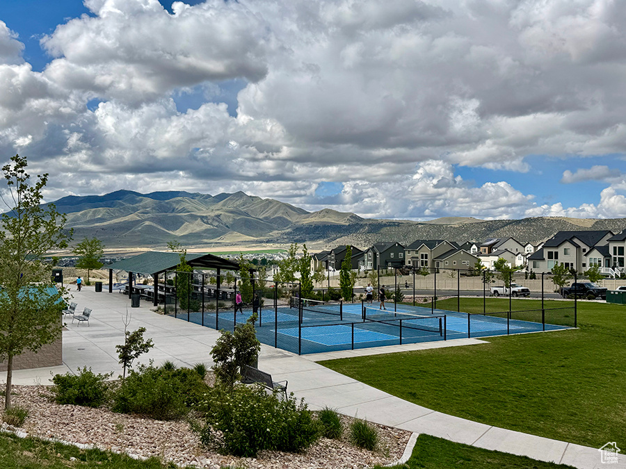 View of tennis court featuring a residential view and a mountain view