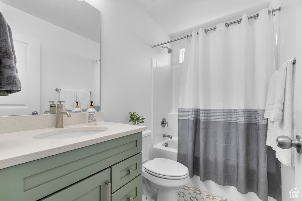 Bathroom featuring shower / tub combo, vanity, and toilet