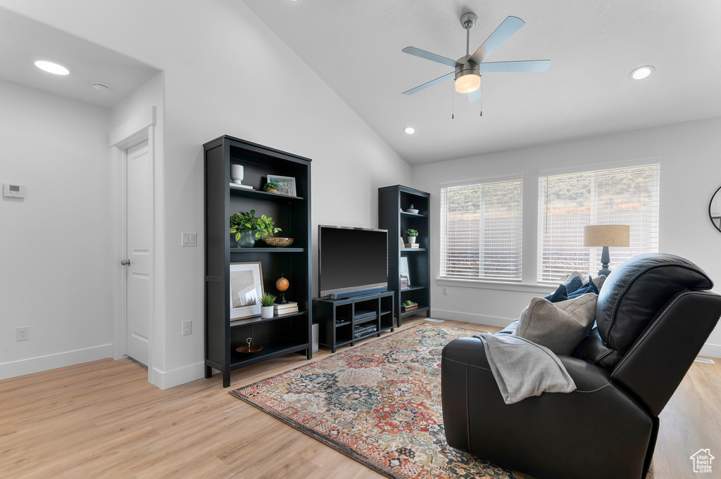 Living room featuring a ceiling fan, light wood-style floors, lofted ceiling, baseboards, and recessed lighting