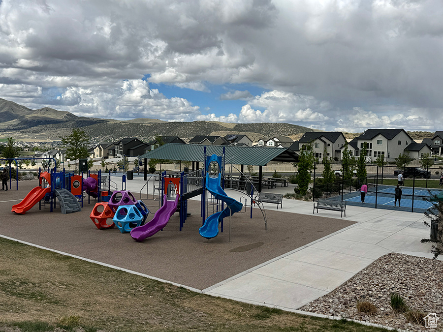 Community jungle gym with a residential view, a mountain view, and fence