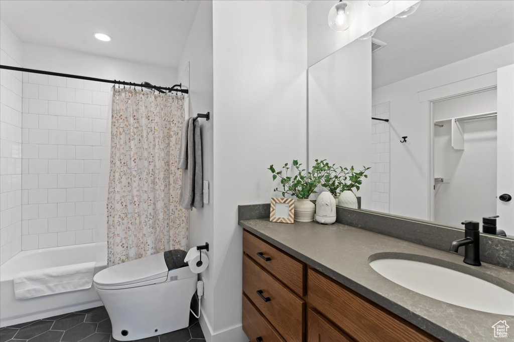 Bathroom with tile patterned floors, vanity, toilet, shower / tub combo, and recessed lighting