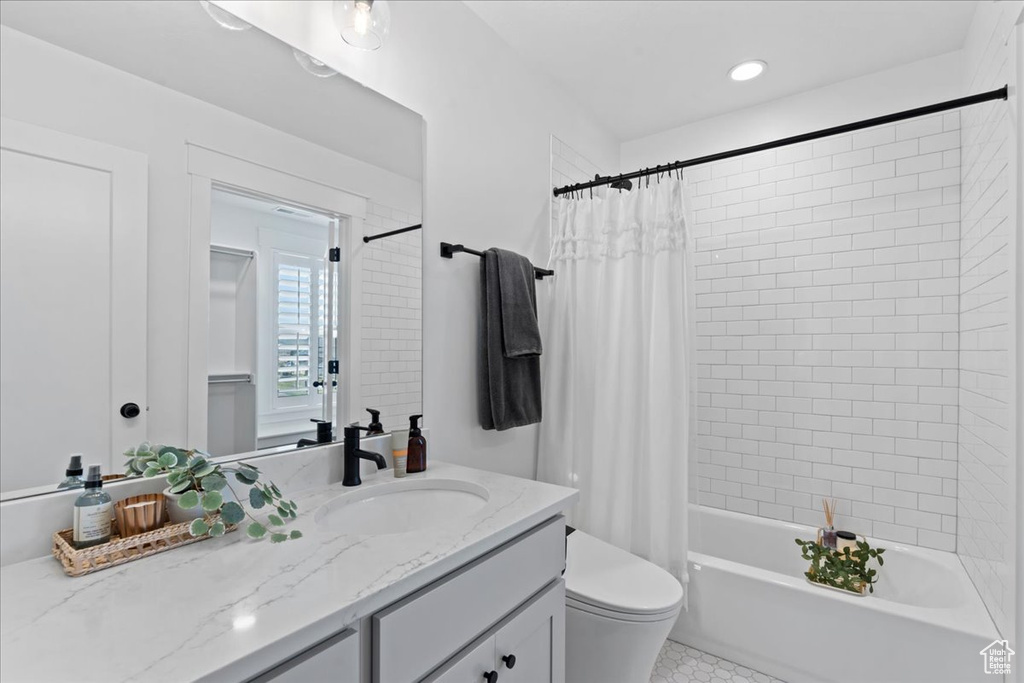 Full bath featuring vanity, shower / tub combo with curtain, toilet, and tile patterned flooring