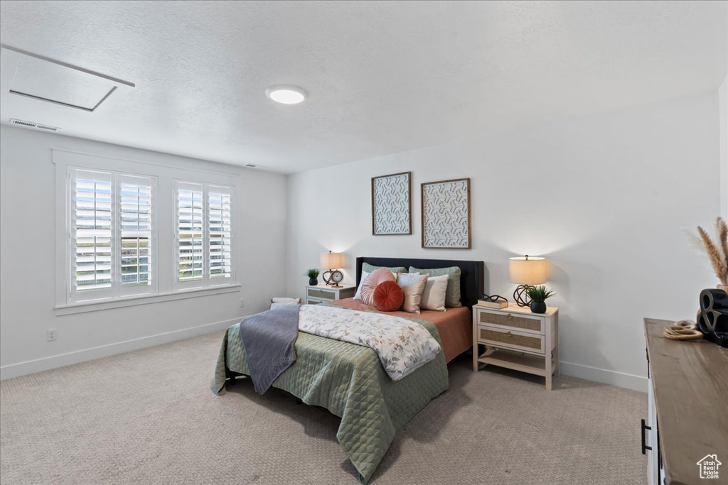 Bedroom with baseboards, carpet, and attic access