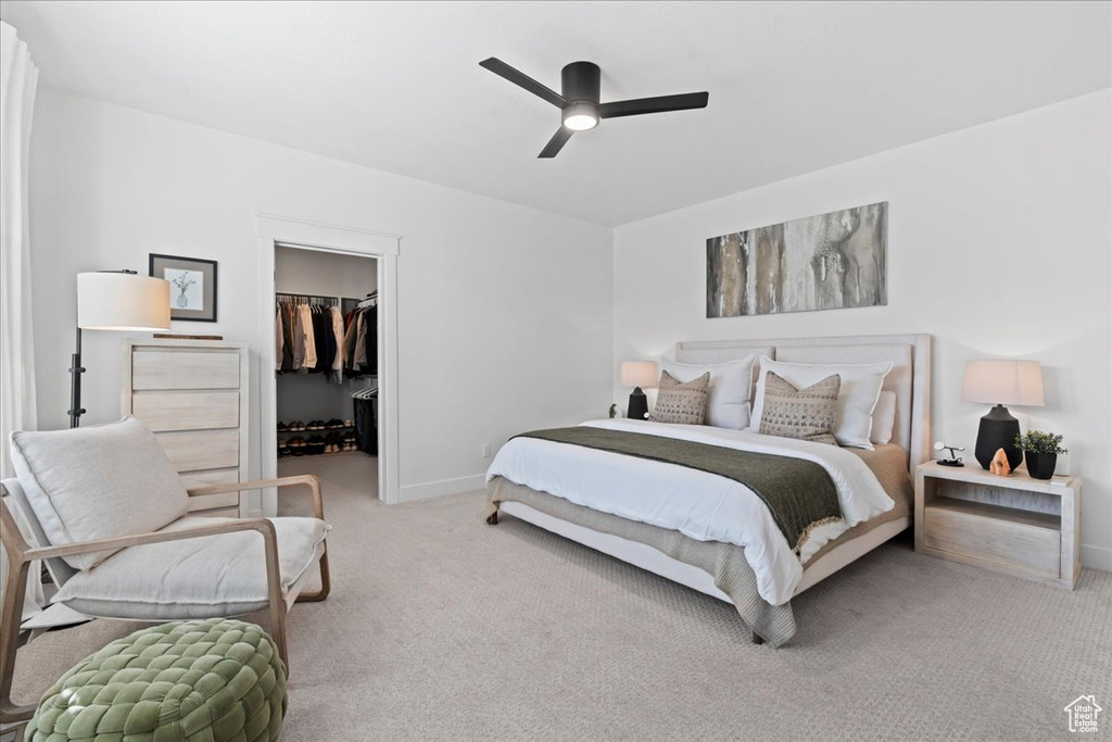Bedroom with carpet flooring, a walk in closet, baseboards, a closet, and ceiling fan