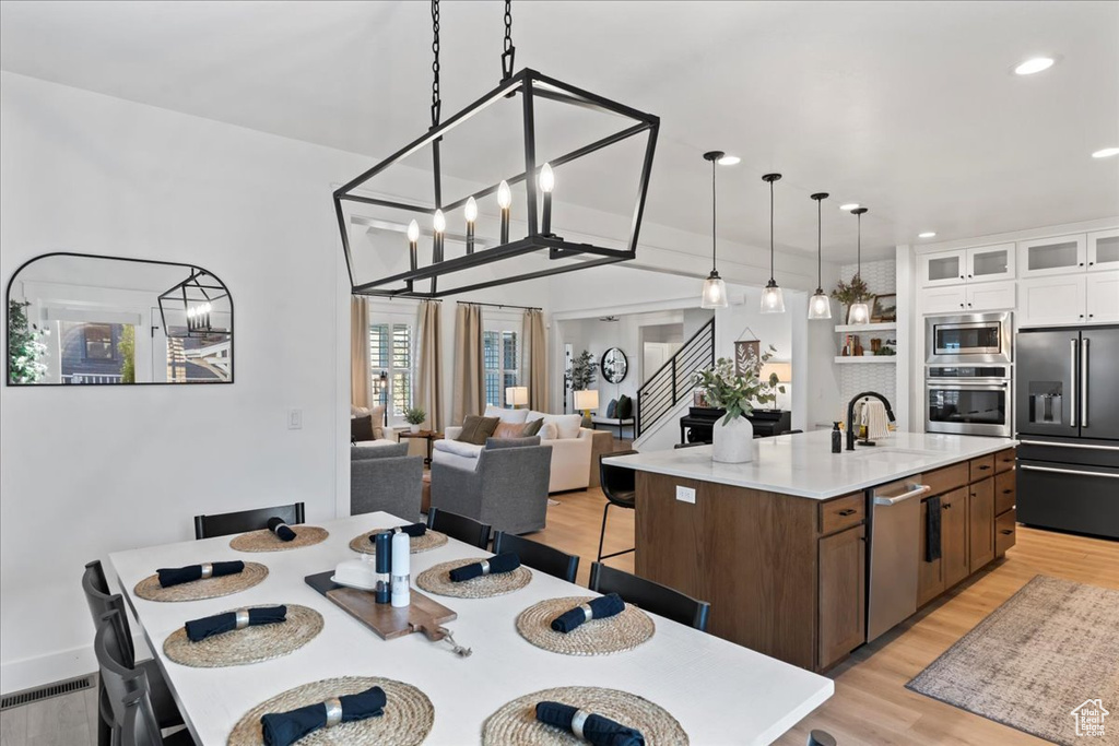 Dining area featuring light wood finished floors, stairway, recessed lighting, and a chandelier