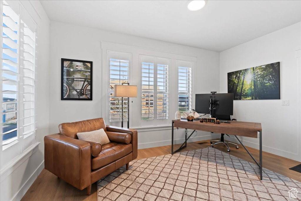 Office area with healthy amount of natural light, wood finished floors, and baseboards
