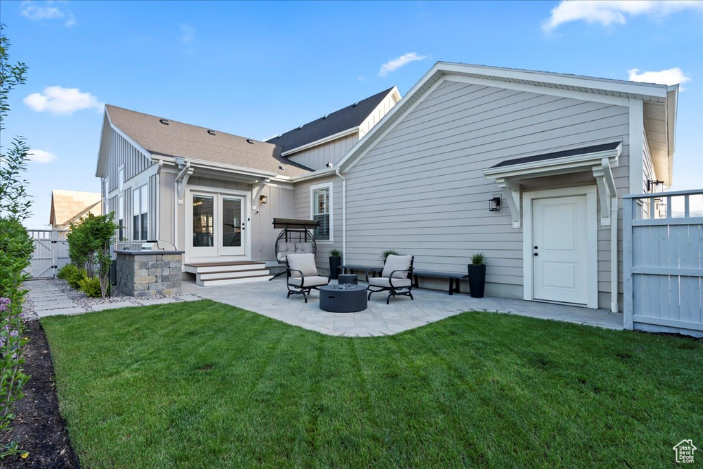 Back of property with a patio, french doors, a fire pit, and board and batten siding