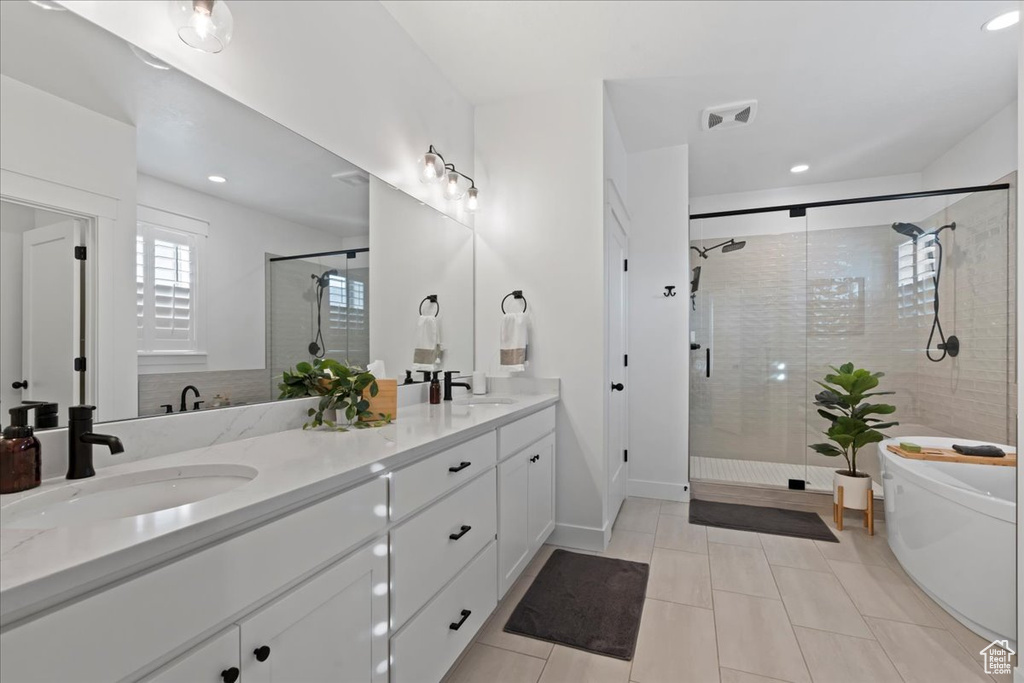 Bathroom featuring a stall shower, recessed lighting, double vanity, and tile patterned flooring