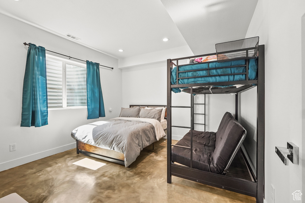 Bedroom featuring concrete flooring, baseboards, and recessed lighting