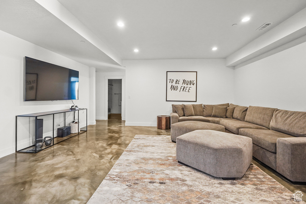 Living area with finished concrete flooring, baseboards, and recessed lighting