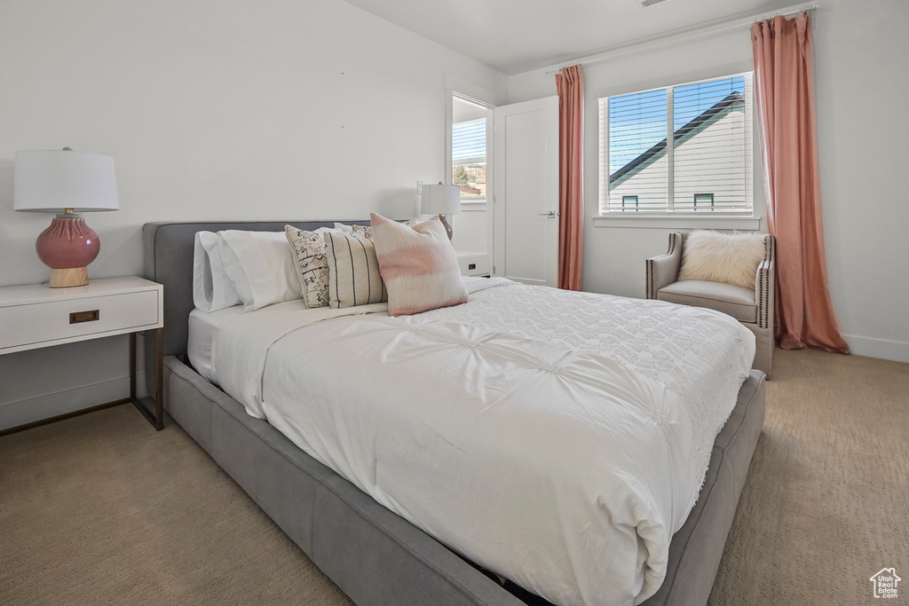 Bedroom with light colored carpet and baseboards