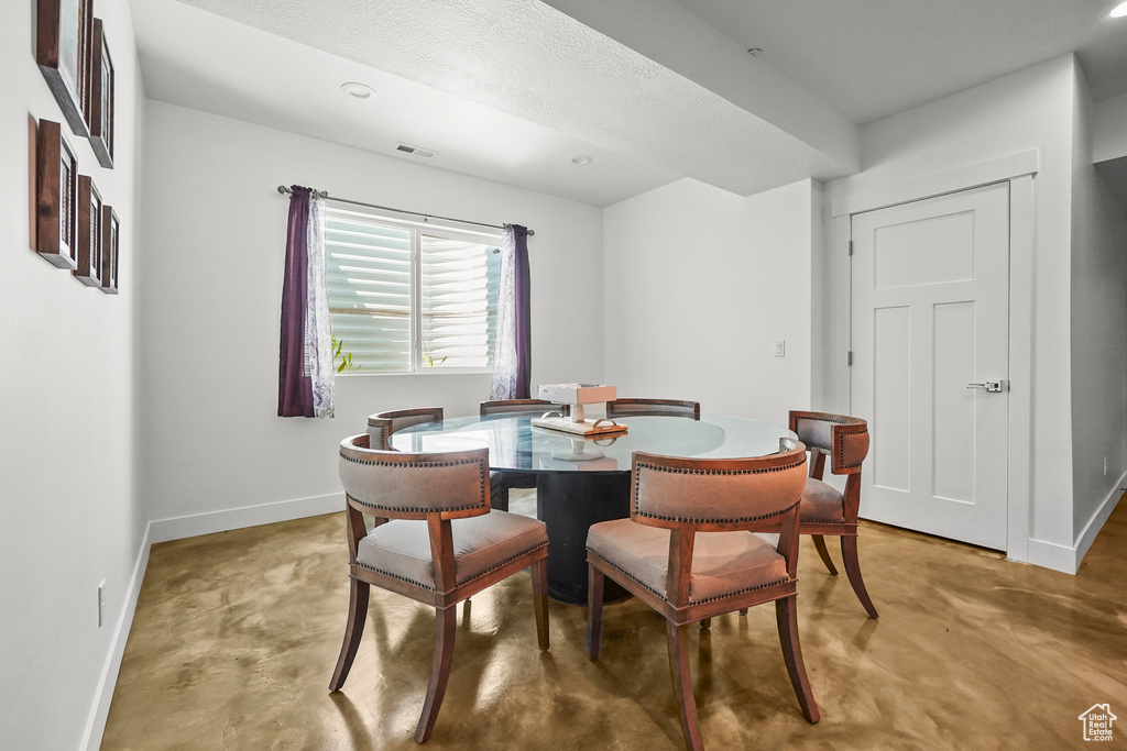 Dining area featuring concrete flooring and baseboards