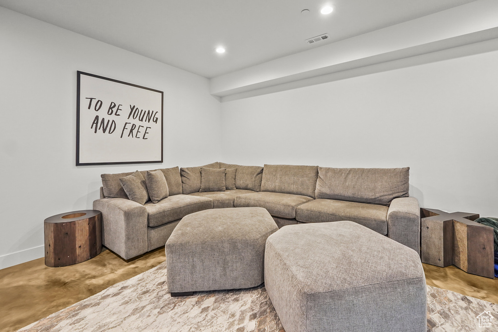 Living area with finished concrete floors, recessed lighting, and baseboards