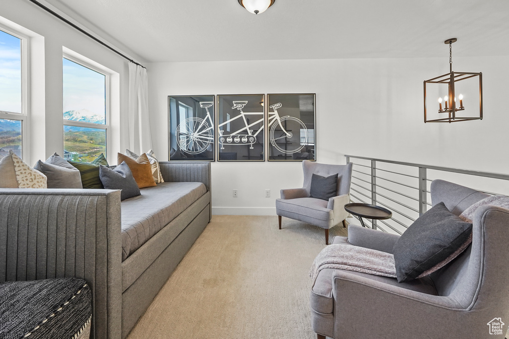 Living area with a chandelier, carpet flooring, and baseboards