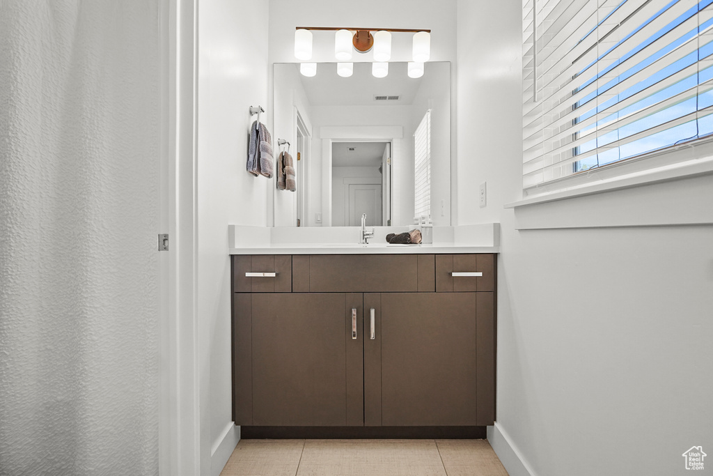 Bathroom with baseboards, vanity, and tile patterned floors