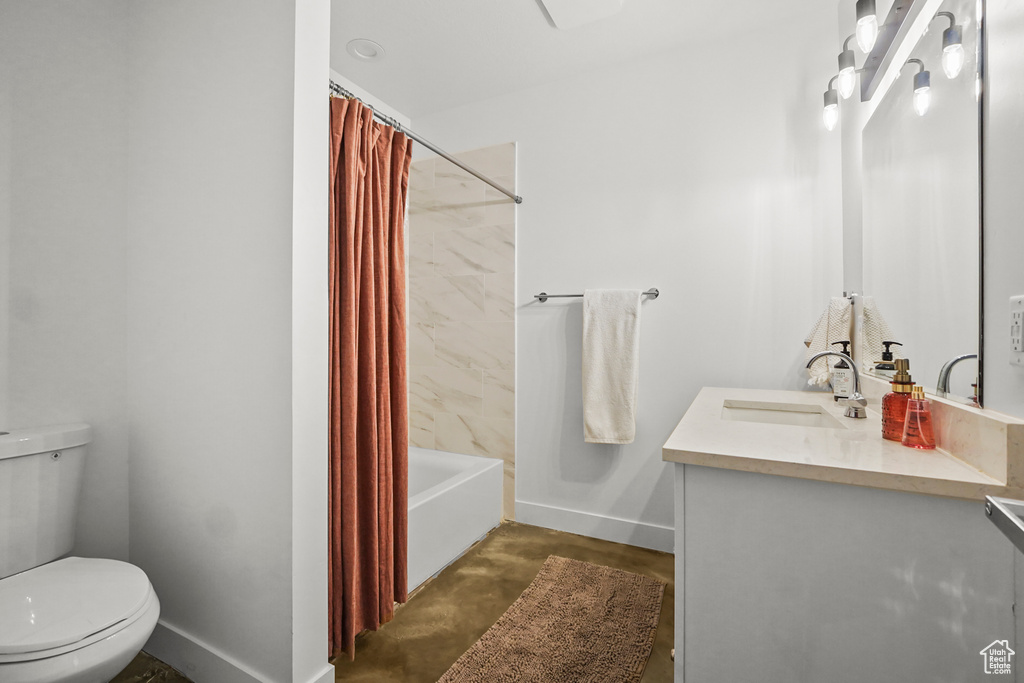 Bathroom featuring toilet, baseboards, shower / tub combo with curtain, vanity, and concrete flooring