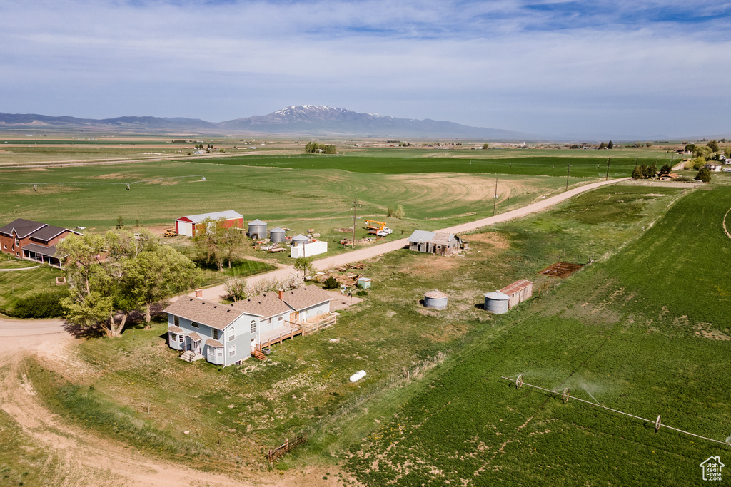 Aerial view of property and surrounding area featuring rural landscape and a mountainous background
