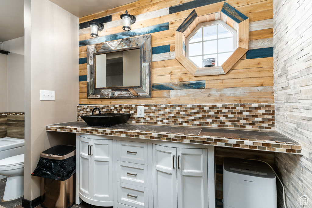 Bathroom with backsplash, toilet, and vanity