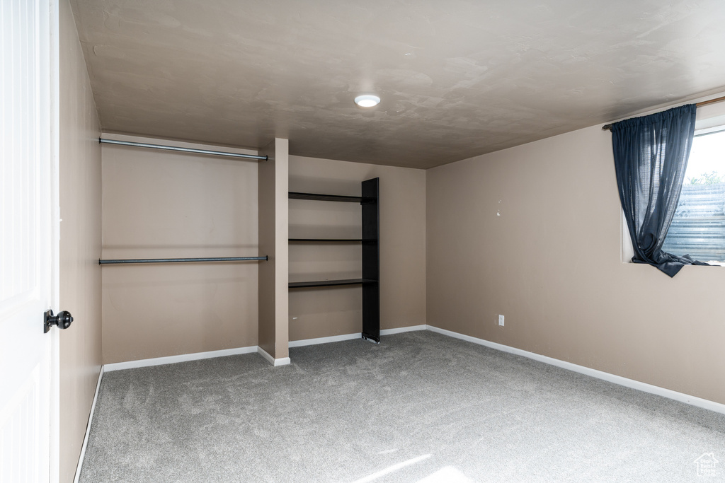 Unfurnished bedroom with carpet floors and baseboards
