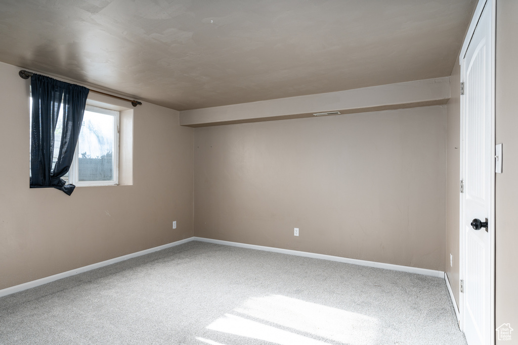 Carpeted empty room with baseboards