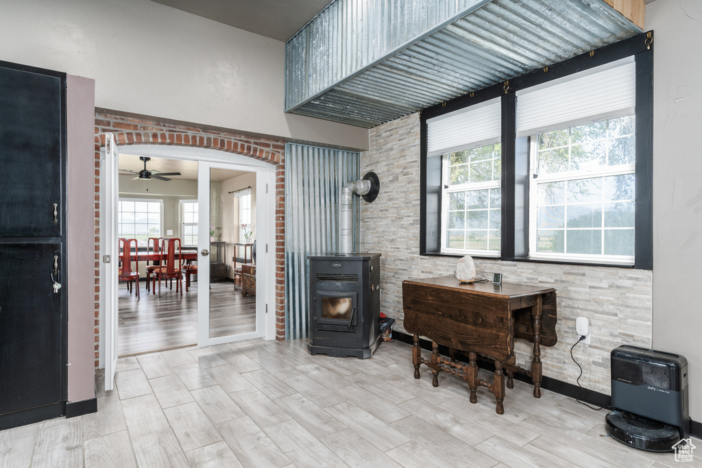 Sitting room featuring a wood stove, ceiling fan, wood finished floors, and heating unit