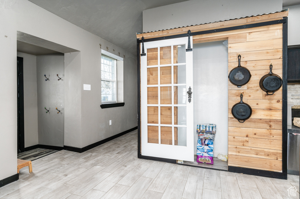 Doorway featuring wood finished floors, baseboards, and a barn door