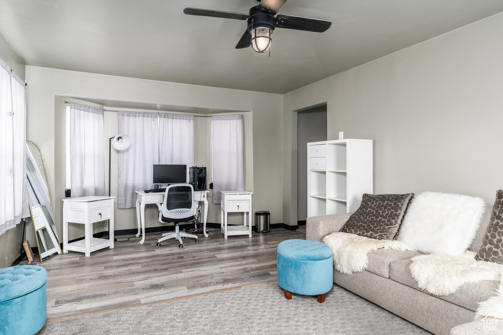 Office space with ceiling fan, wood finished floors, and baseboards