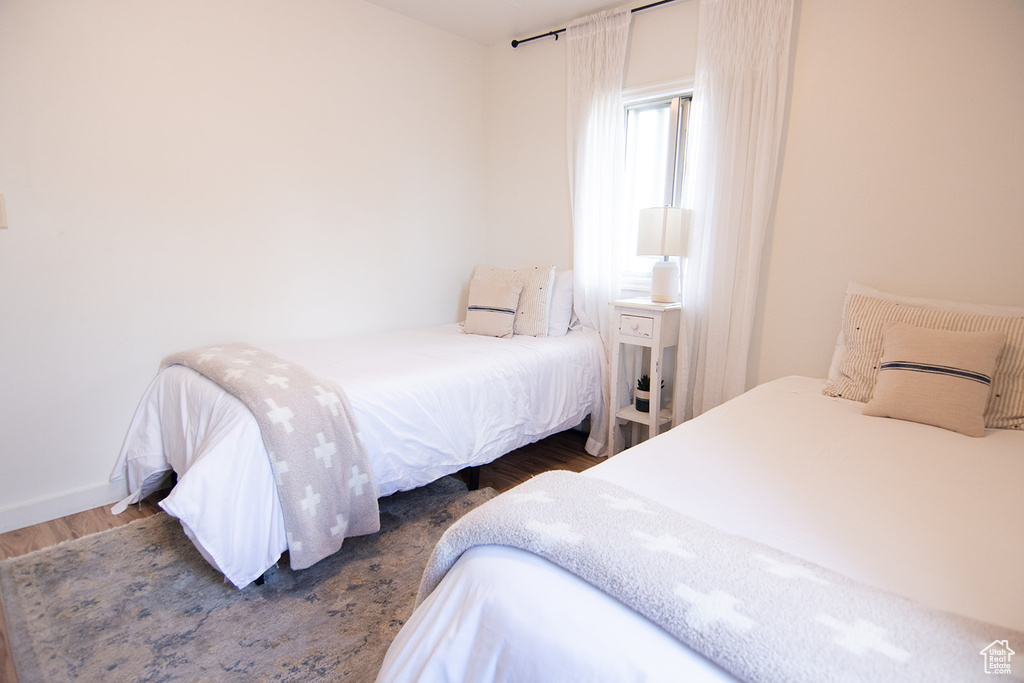 Bedroom with wood finished floors and baseboards