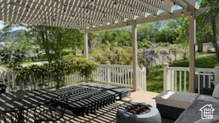 View of patio with a pergola and a fire pit