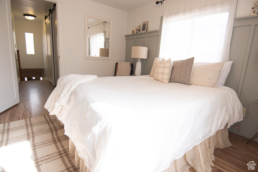 Bedroom featuring wood finished floors and a barn door