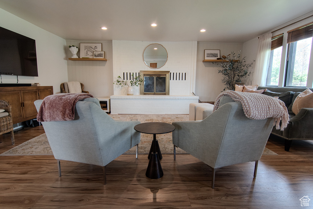 Living room featuring wood finished floors, a brick fireplace, and recessed lighting