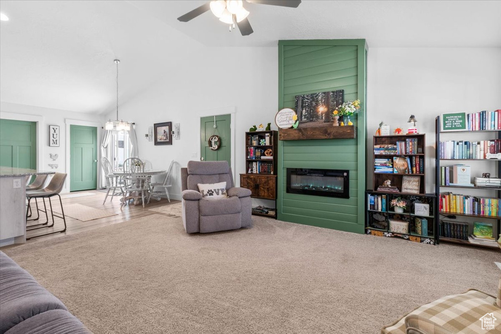 Living room with a fireplace, vaulted ceiling, and a ceiling fan