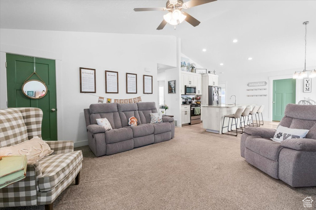 Living area featuring light carpet, a ceiling fan, recessed lighting, and high vaulted ceiling