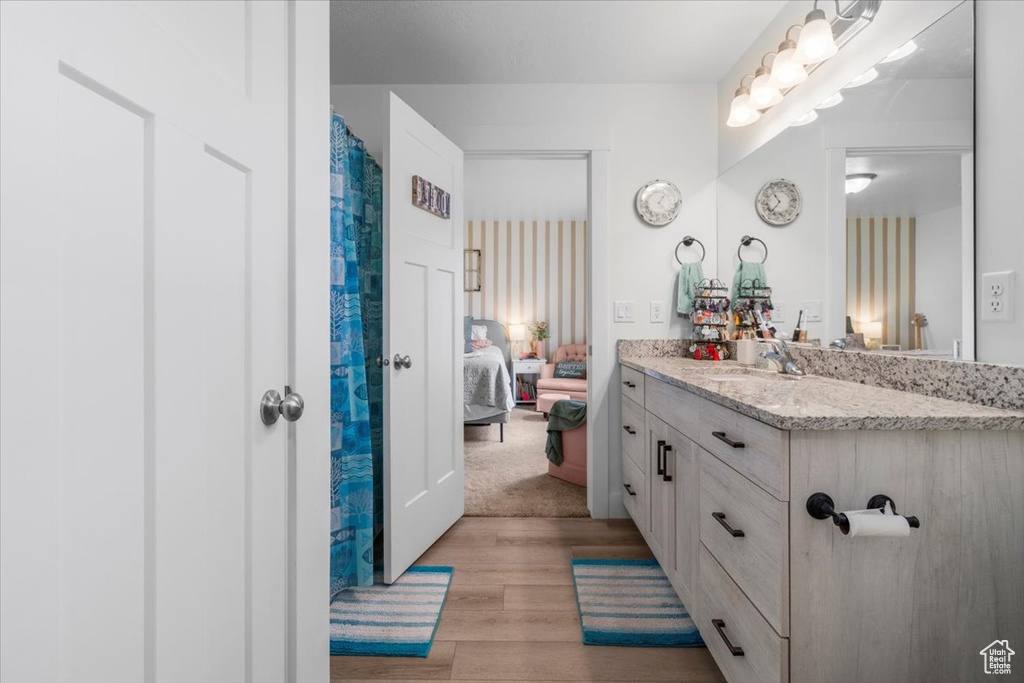 Bathroom with wood finished floors, vanity, and ensuite bathroom