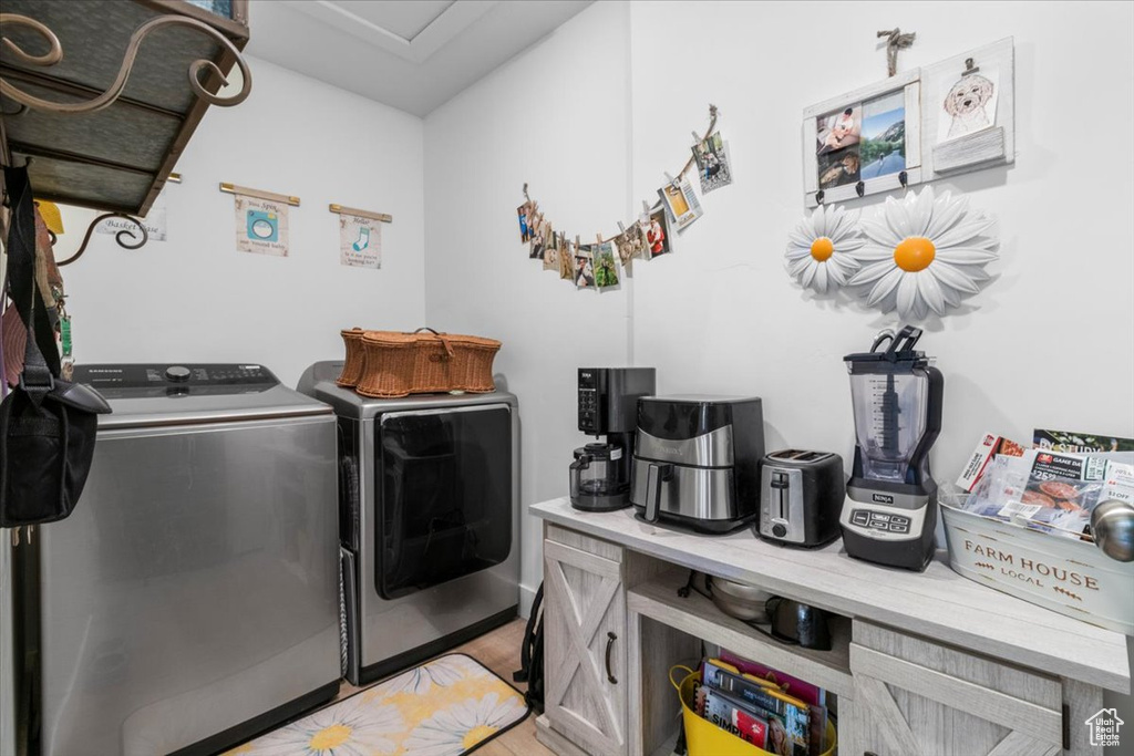 Washroom with independent washer and dryer and light wood-style floors