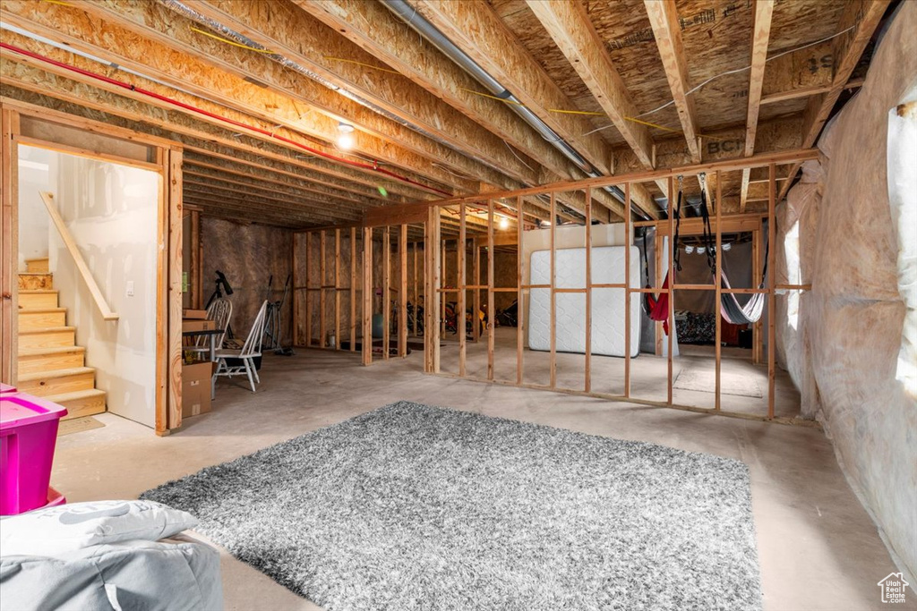 Unfinished below grade area featuring stairs and heating unit