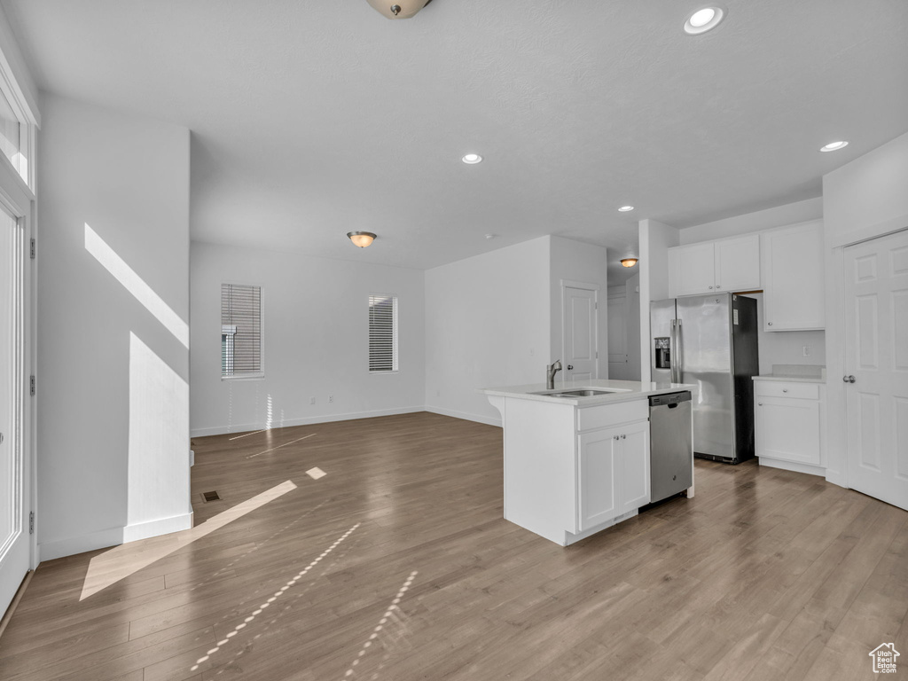 Kitchen featuring appliances with stainless steel finishes, a sink, white cabinetry, baseboards, and recessed lighting