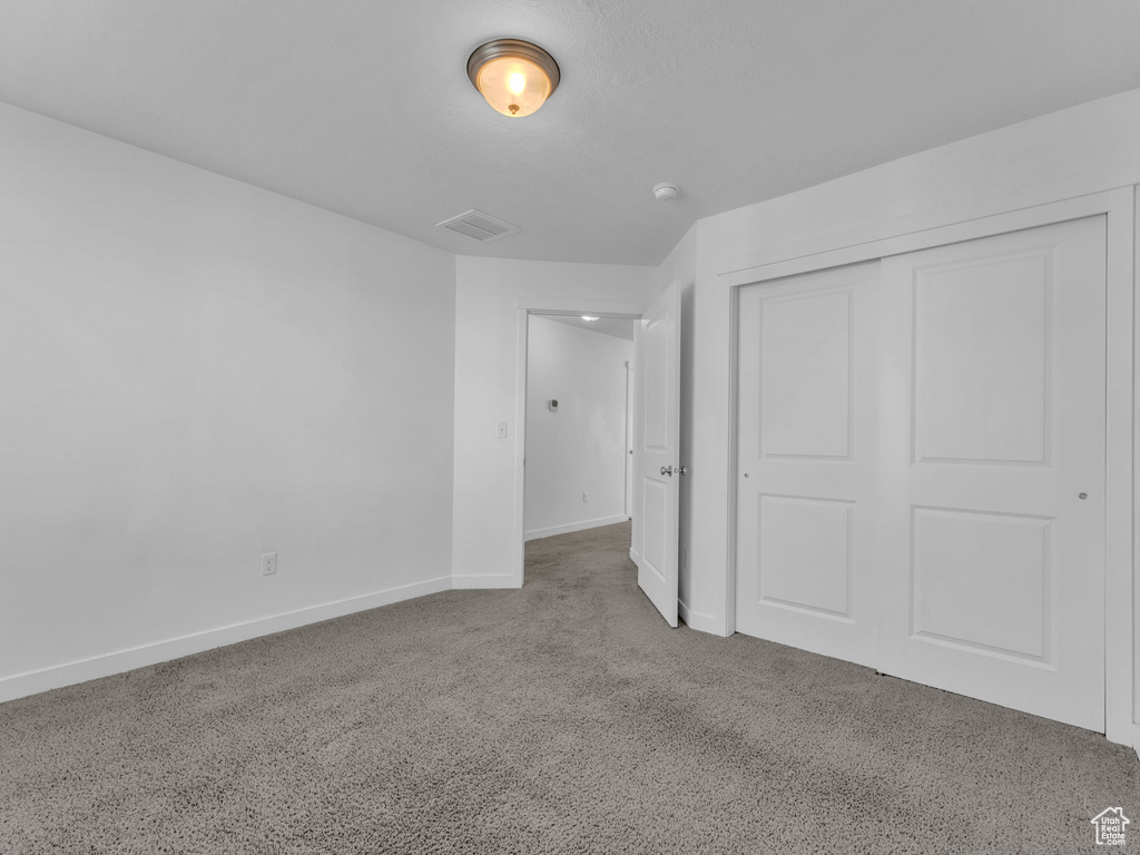 Unfurnished bedroom with baseboards, carpet floors, and a closet